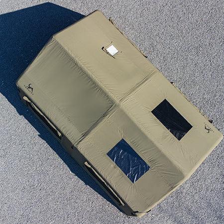 Aerial view of large khaki camping tent with two rectangular windows on gravel surface