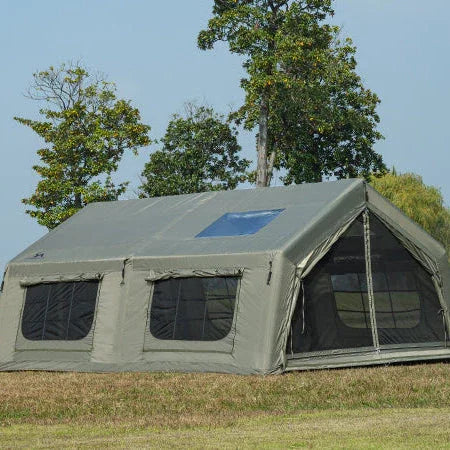 Large canvas camping tent with mesh windows set up outdoors on grass