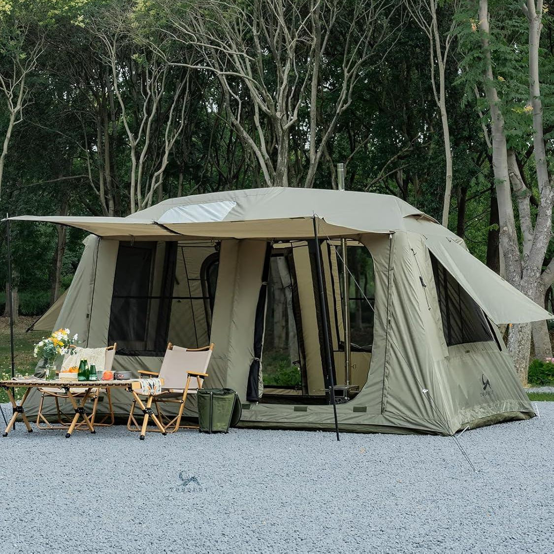 Spacious camping tent with large windows and doors set up outdoors with chairs and a table